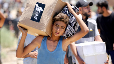 জিএইচএফের ত্রাণকেন্দ্র থেকে ত্রাণ পেয়েছে এক ফিলিস্তিনি। ফাইল ছবি: এএফপি