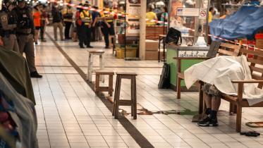 চাতুচাকের অর টর কর সুপারমলে বন্দুকধারীর গুলিতে নিহত এক ব্যক্তির মরদেহ সাদা কাপড় দিয়ে ঢেকে রাখা হয়েছে। ছবি: এএফপি