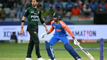 India's Tilak Varma (R) runs between the wickets as Pakistan's Shaheen Shah Afridi watches 
