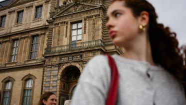 ল্যুভর জাদুঘরের যে জানালা দিয়ে চোর ঢুকেছিল, সেটার সামনে দাঁড়িয়ে এক নারী। ছবি: এএফপি