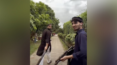 খেলনা বন্দুক হাতে লিমন তোহা ও স্বপন মোল্লা। ছবি: ভিডিও থেকে নেওয়া